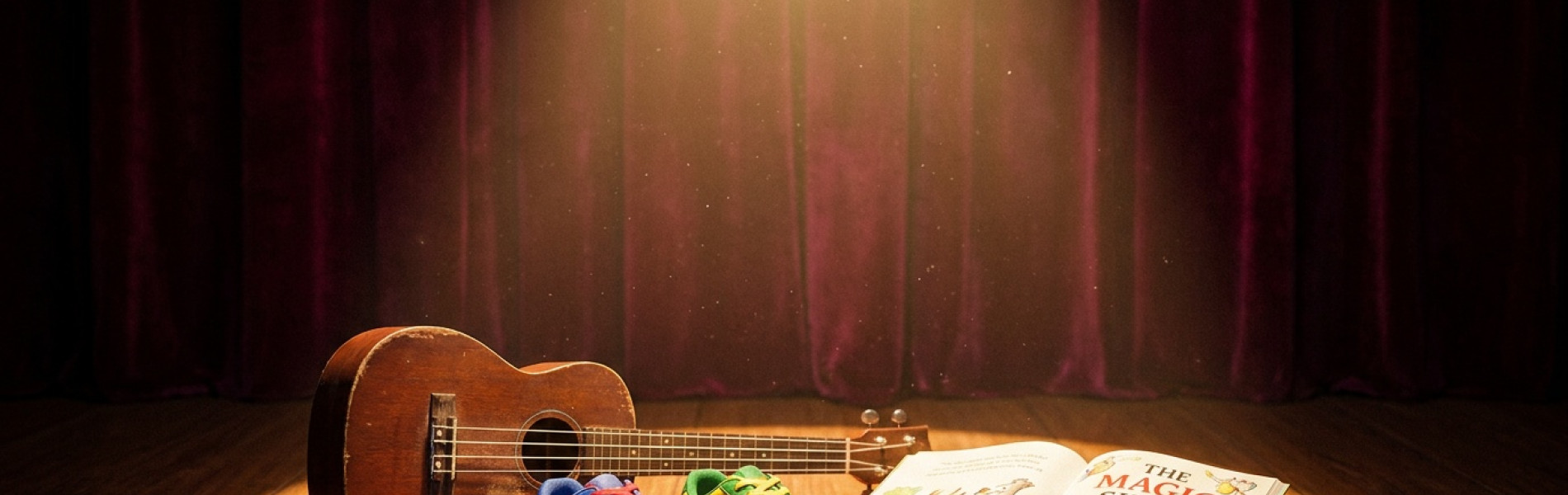 Een felle spotlight die een lichtcirkel werpt op een klein houten podium, met daarop een ukelele, een paar dansschoenen en een open kinderboek